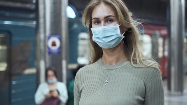 Жінка в масці ходить по переповненій станції метро коронавірус. Дівчина йде в метро ковадла-19 — стокове відео