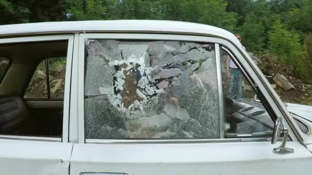 L'homme fou détruit la voiture a frappé le pied de biche. Les gens agressent le véhicule en verre brisé vandale. — Video