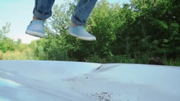 Божевільна людина стрибає на дах знищити машину. Чоловік злітає зламаний транспортний засіб . — стокове відео