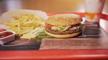 Kadın fast food restoranı McDonalds 'dan besleyici yemek sipariş ediyor. Lezzetli hamburger.