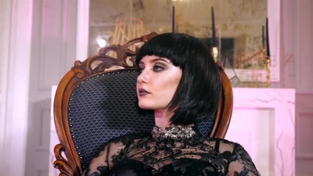Sebevědomí portrét gotická žena sedí židle detailní. Bohatá dívka se dívá do kamery. — Stock video