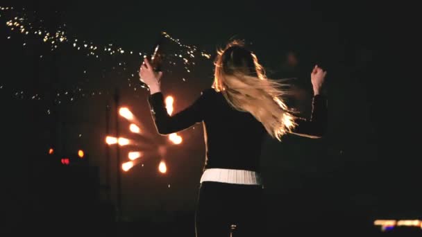 Κορίτσι πιτσιλίζει σαμπάνια με φωτεινά πυροτεχνήματα γιορτάζουν τη νύχτα στην οροφή της πόλης. — Αρχείο Βίντεο