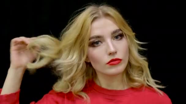 Portret meisje in rood voorbereiding kapsel. Cosmetische rode lippen make-up gezicht blond. — Stockvideo