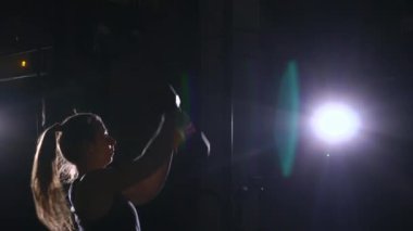 Güçlü bayan sporcu tarafından yapılan aptal güç kapma hareketi. Kettlebell kapıyor