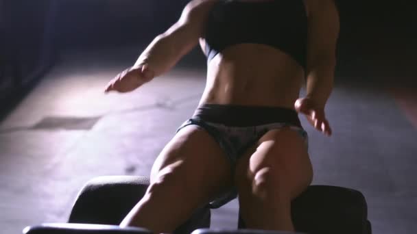 La atleta se acurruca en la colchoneta del gimnasio. Fuerte delgado señora fitness sentarse en el interior — Vídeos de Stock