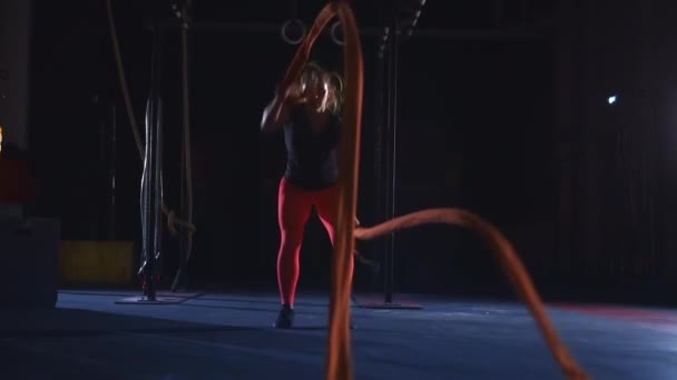 Γυναίκα αθλητής κυματίζει βαριά μακριά σχοινιά μάχης. Ασκήσεις κύμα σχοινί μάχης. — Αρχείο Βίντεο