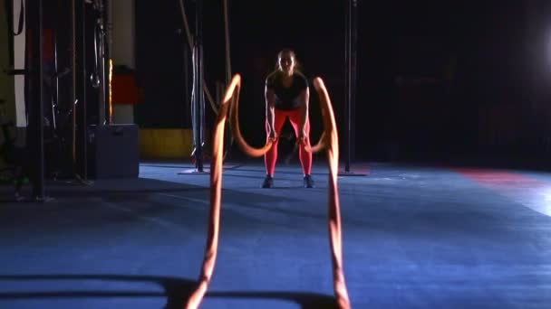Atleta feminina acena pesadas cordas de luta longas. Exercícios de onda de corda de batalha. — Vídeo de Stock