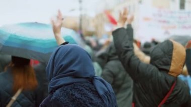Şiddet içermeyen gösteri kalabalığı şehir meydanında el sallıyor. Zararsız eylemcilik.