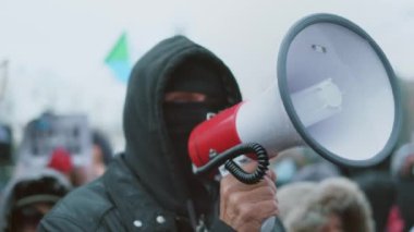 Angry male protester talking with megaphone. Peaceful civil right man activist.