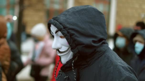 City anti government strike. Anonym in Guy Fawkes mask walks down the street. — Stock Video