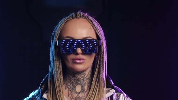 Nyíl LED szemüveg nő nézi a kamerát. Hipnotikus szőke női copfok 4K. — Stock videók