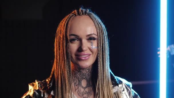 Felice ritratto femminile sorriso. Sfondo al neon. Bionda stretto dreadlock trecce sguardo — Video Stock