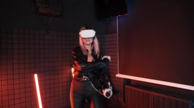 Modayı takip eden VR kızı kamera karşısında el ele tutuşuyor. Sanal gerçeklik gözlükleri aktif oyunlar.