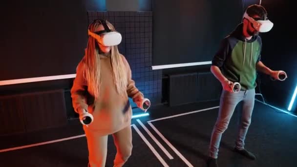 Zábavná soutěž virtuální reality. Dospělý pár hraje na oculus vr bicí. Neonové světlo. — Stock video