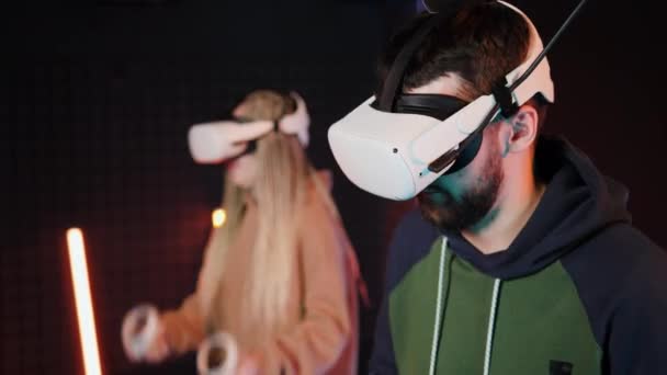 Kul virtuell verklighet konkurrens. Vuxna par spelar okulus vr trummor. Neonljus. — Stockvideo