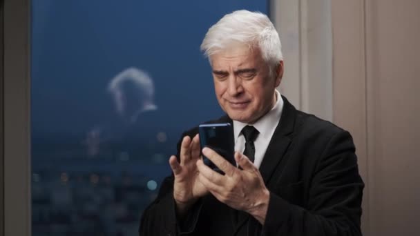Veselý starší podnikatel v blejzru s mobilním telefonem smskování a usmívání. — Stock video