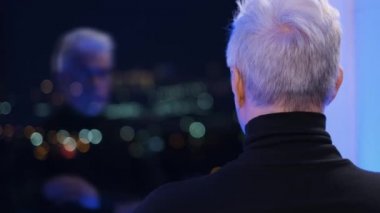 Akli dengesi bozuk balıkçı yakalı yaşlı beyefendi aynadaki yansımaya bakıyor..