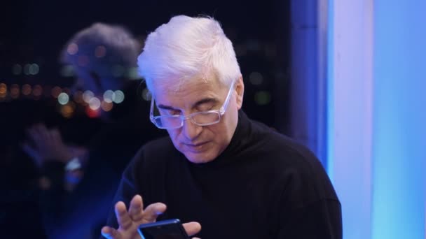 Ηλικιωμένος λευκός συνταξιούχος άνδρας με γυαλιά ηλίου και ζιβάγκο με κινητό μήνυμα. — Αρχείο Βίντεο