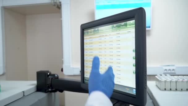 손에 장갑을 끼고 있는 의사는 병원의 터치 스크린 모니터에서 데이터를 분석 한다. — 비디오