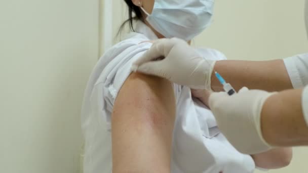 Pandemický lékař aplikuje vakcínu. Předem dezinfikuje pacientovu paži. — Stock video