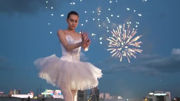 Балерина танцює пірует дивовижний балет, який прославляє яскраві вогневі роботи на даху.. — стокове відео
