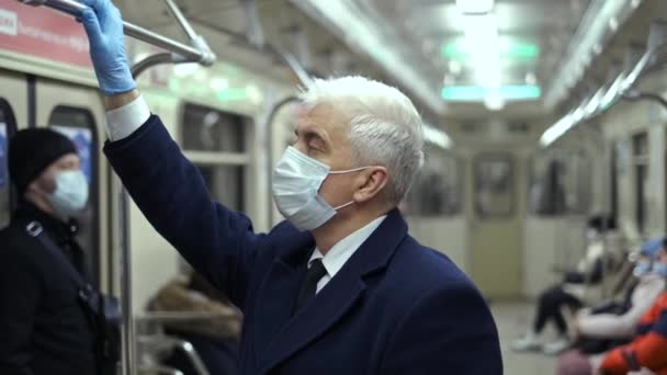 Masked man in metro carriage holds handrail while standing. Subway in lockdown. — Stock Video