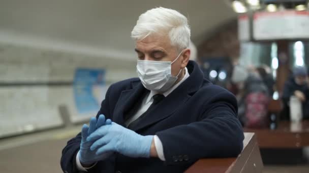 Berlin metro station. Elder person in mask and gloves due to covid sits, waits. — Stock Video