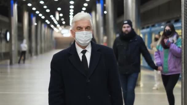 Pembatasan pandemik di metro. Orang tua berjalan dengan masker wajah di kereta bawah tanah. — Stok Video