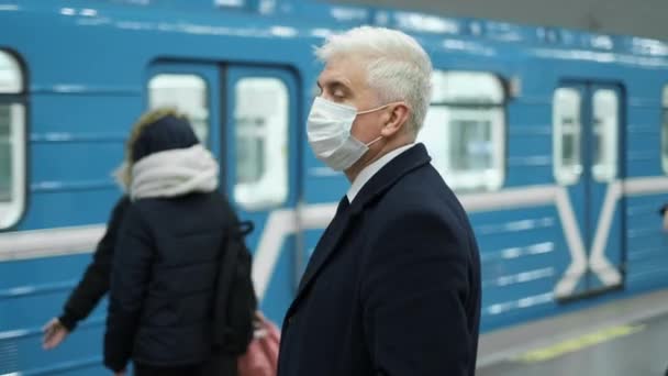 Vár a földalatti kocsi. Idősebb férfi arcmaszkban álljon az állomáson. — Stock videók