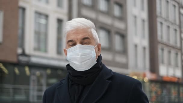 Portrait de messieurs aux cheveux gris hollandais en manteau noir et masque regardant la caméra — Video