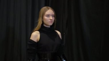 Açık kahverengi saçlı kız defilede podyum gösterisi yapıyor. Podyumu kirlet.