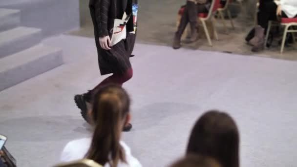女の子はファッションショーの段階で建物ハンマーを運びます.カジュアル衣装｜vogue catwalk. — ストック動画