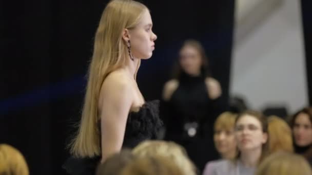 Female fashion model with light colored blonde hair on catwalk podium runway. — Stock Video