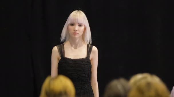 Blanke albino haar meisje beweegt op catwalk podium. Vrouwelijk model verontreinigt. — Stockvideo