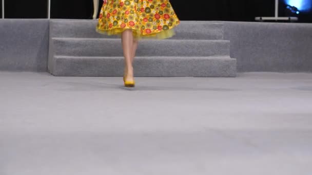 Yellow pumps sandals on feet of woman model that walks on catwalk defile podium. — Stock Video