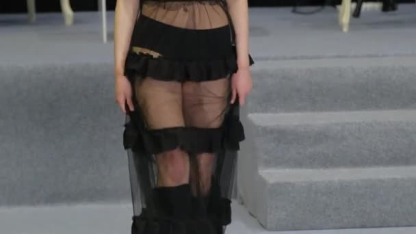 Chica modelo rubia en vestido transparente camina en el podio desfilar. Pasarela de moda. — Vídeo de stock