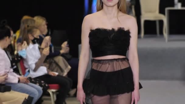 Blond model meisje in transparante jurk loopt op verontreinigen podium. Fashion catwalk. — Stockvideo