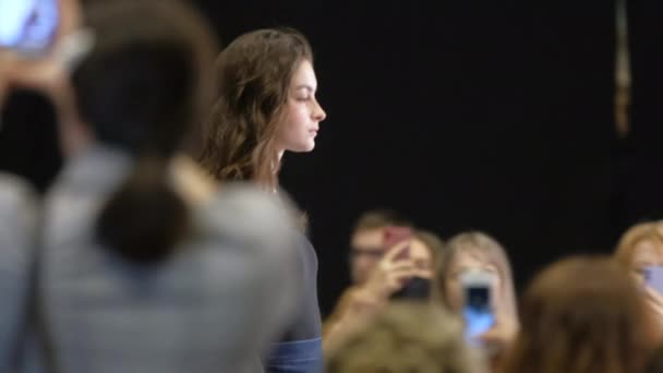 Brunet nainen palkintokorokkeella catwalk aikana muotinäytös viikolla. Vogue-kiitotien viat. — kuvapankkivideo