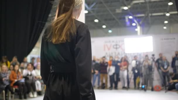 Trendy female model in black plain dress walking on fashion catwalk defile show. — Stock Video