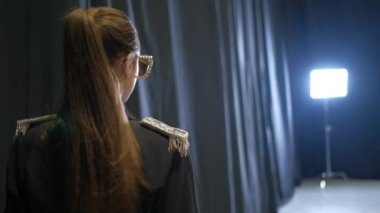 Moda podyumunda gümüş apoletli ve zincirli esmer model..