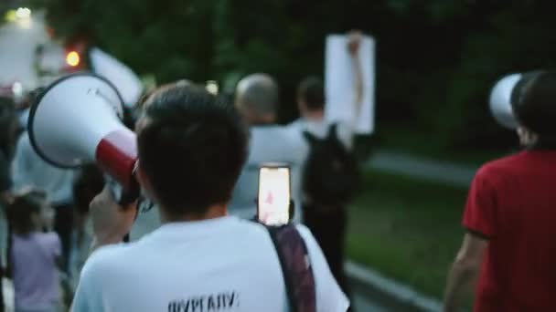 Militant mégaphone parle tout en marchant dans la foule des manifestants de piquetage politique — Video