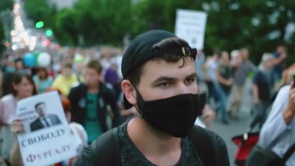 Manifestante uomo in maschera civettuola camminando in restrizioni opposizione folla persone. — Video Stock