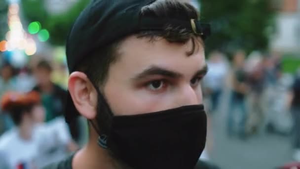 Masked face of guy in crowd of political opposition of coronavirus restrictions. — Stock Video