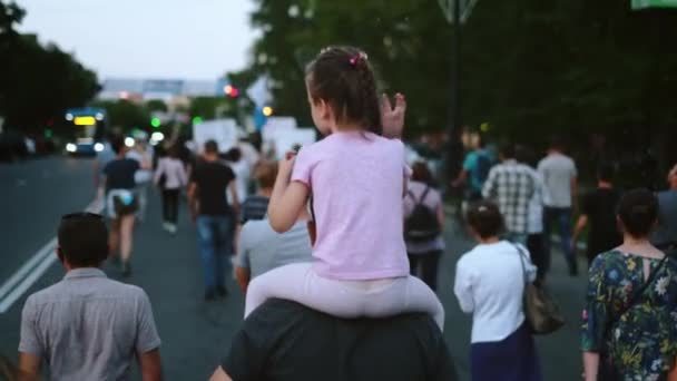 Tochter mit Vater auf politischer Kundgebung randaliert. Mädchen sitzt auf den Schultern der Eltern. — Stockvideo