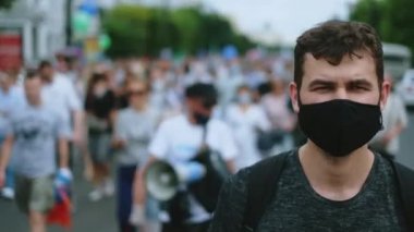 Siyahi maskeli bir protestocu kısıtlamalarla yürüyor..