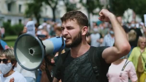 Agresivní protestant s houkačkou na rally. Naštvaný aktivista nepokojů s megafonem. — Stock video