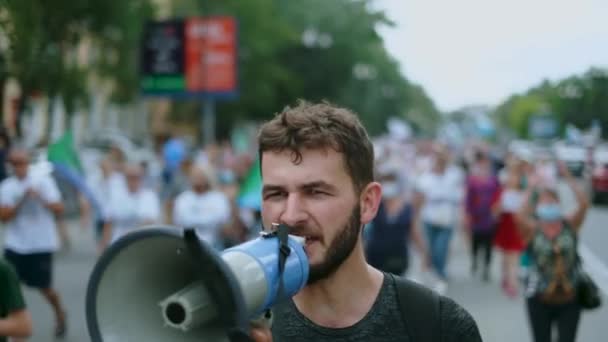 Angry protester with bullhorn walks and talks. Shouting with megaphone activist — Stock Video