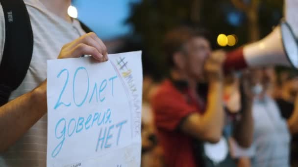 Man protesterar talar med megafon bullhorn medan aktivist håller banner tecken. — Stockvideo
