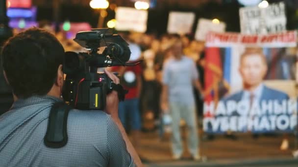 Operador de cámara de video filma rebeldes con carteles en demostración de resistencia — Vídeo de stock
