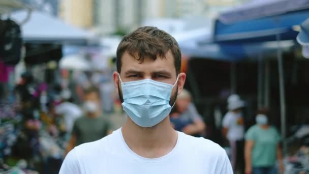 Portret van een gemaskerde man die op de Aziatische markt stond tijdens een coronaviruspandemie. — Stockvideo